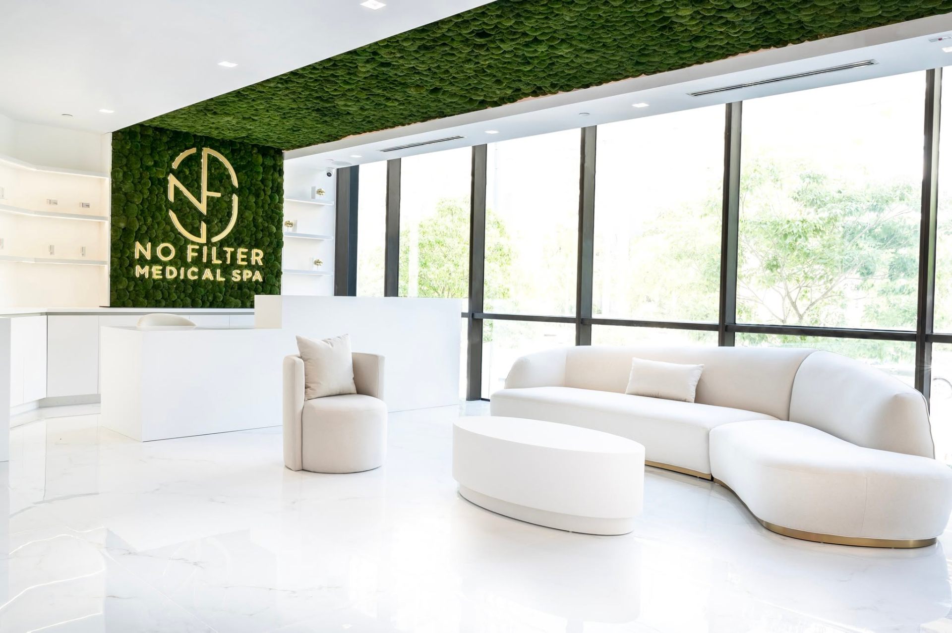 No Filter Medical Spa reception with moss wall and brass logo
