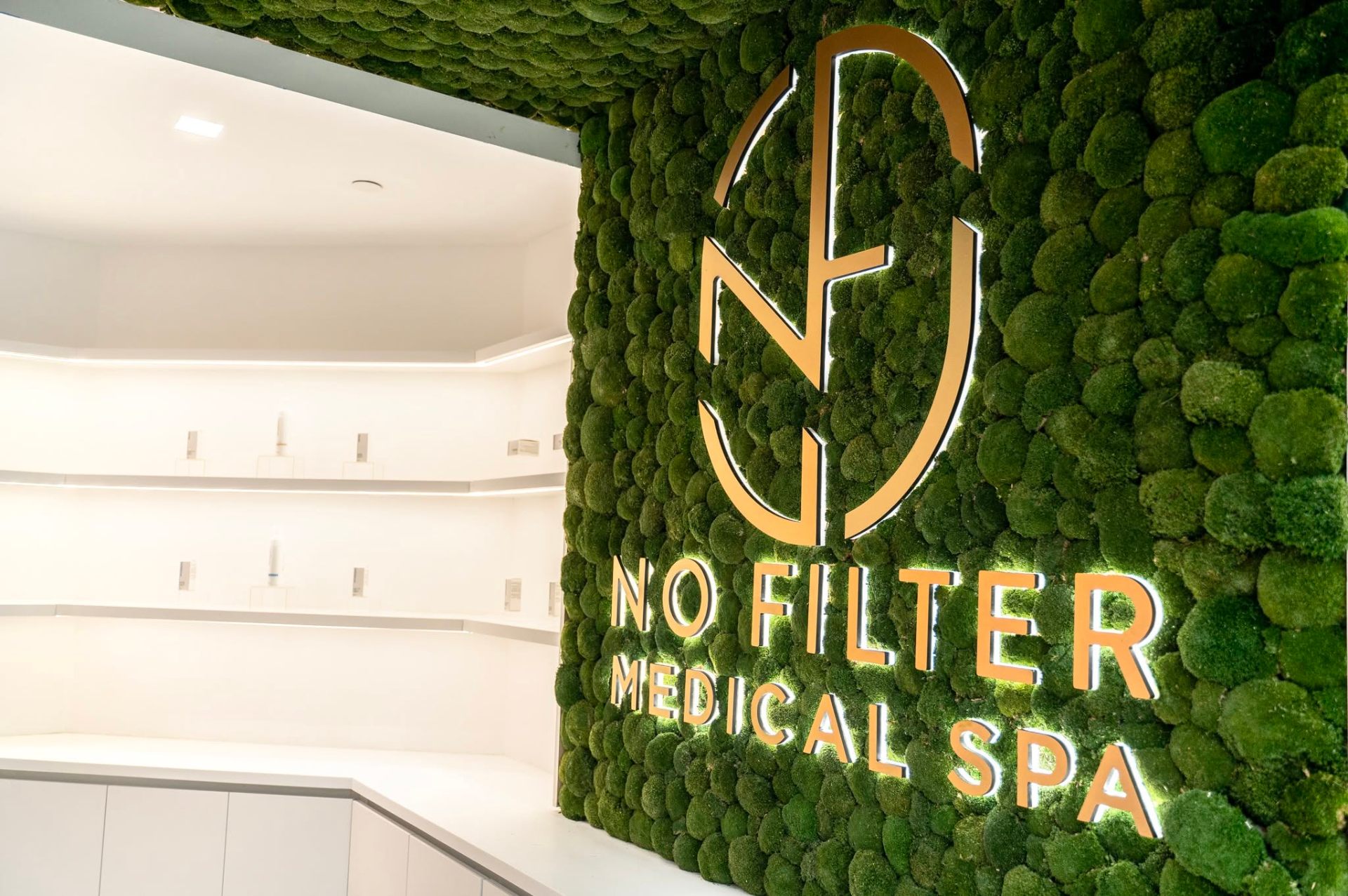 Moss wall detail with backlit No Filter Medical Spa monogram